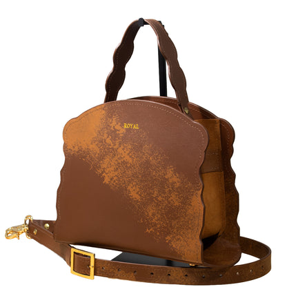 Hand‑painted full‑grain leather Joy satchel handcrafted in brown with artisan multi‑tone accents, shown with a top handle and removable strap.  