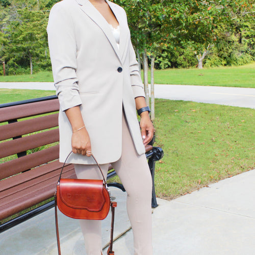 Designer leather crossbody handbag featuring structured top handle and artisan craftsmanship