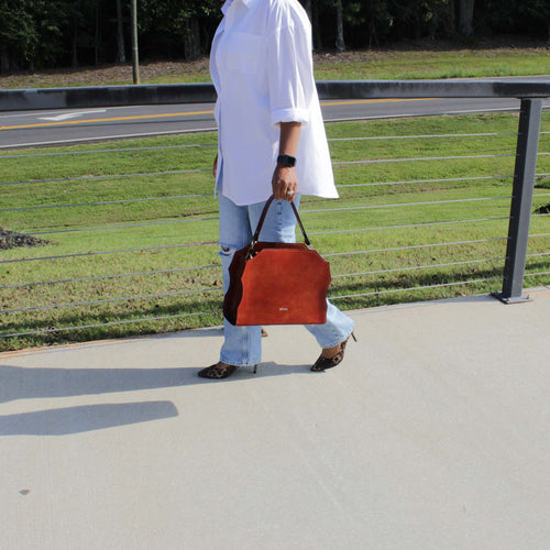 Woman carrying the Forgiveness hand‑painted satchel by structured top handle, artisan design